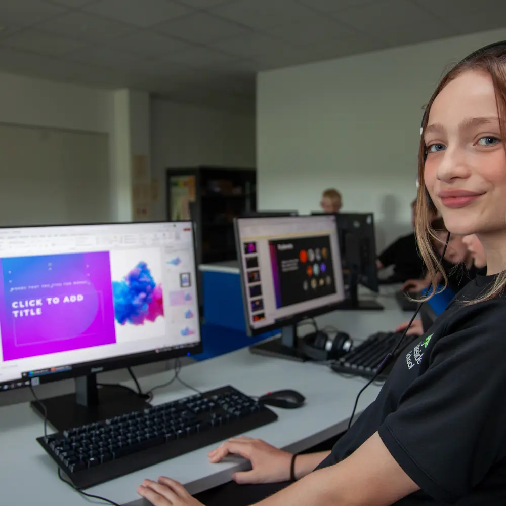 A young girl at Lakeside School using a computer and headphones