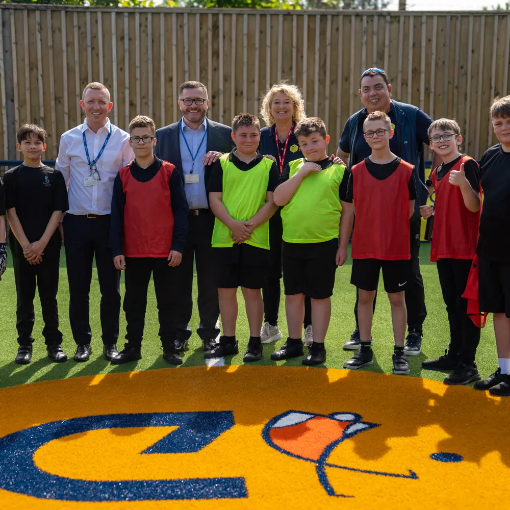Pupils and staff members at Bescot Hall School standing on the Cruyff Court for a photograph