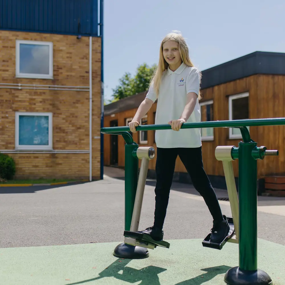 Blonde-haired girl using the outdoor gym at Abbeywood School