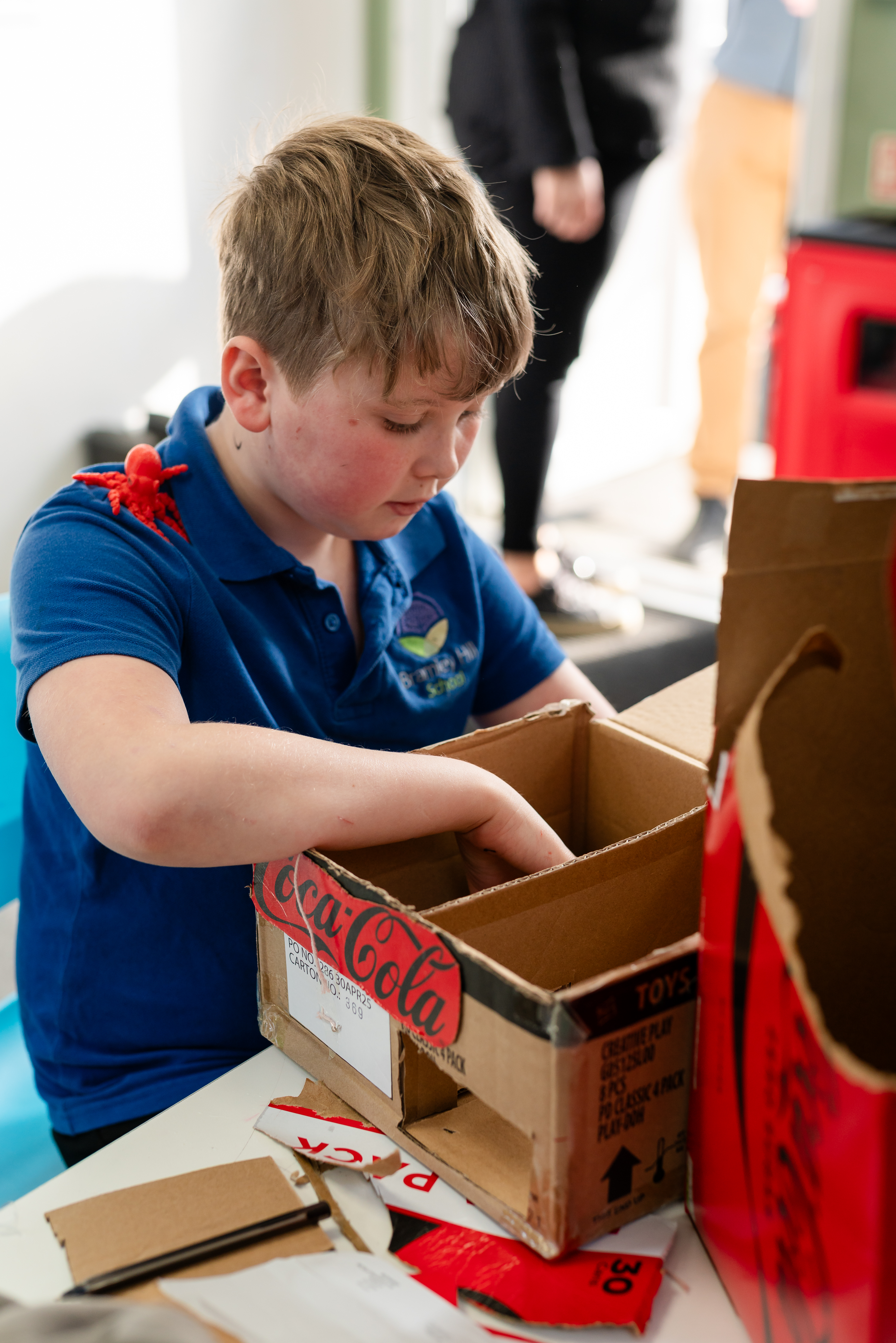 Young boy building a cardboard box