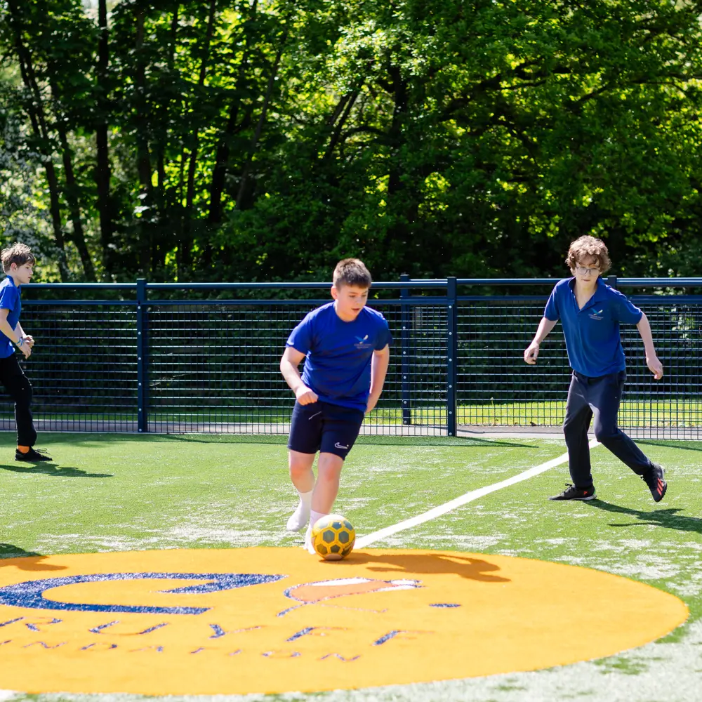 Pupils at Chilworth House Upper School playing football on the Cruyff court