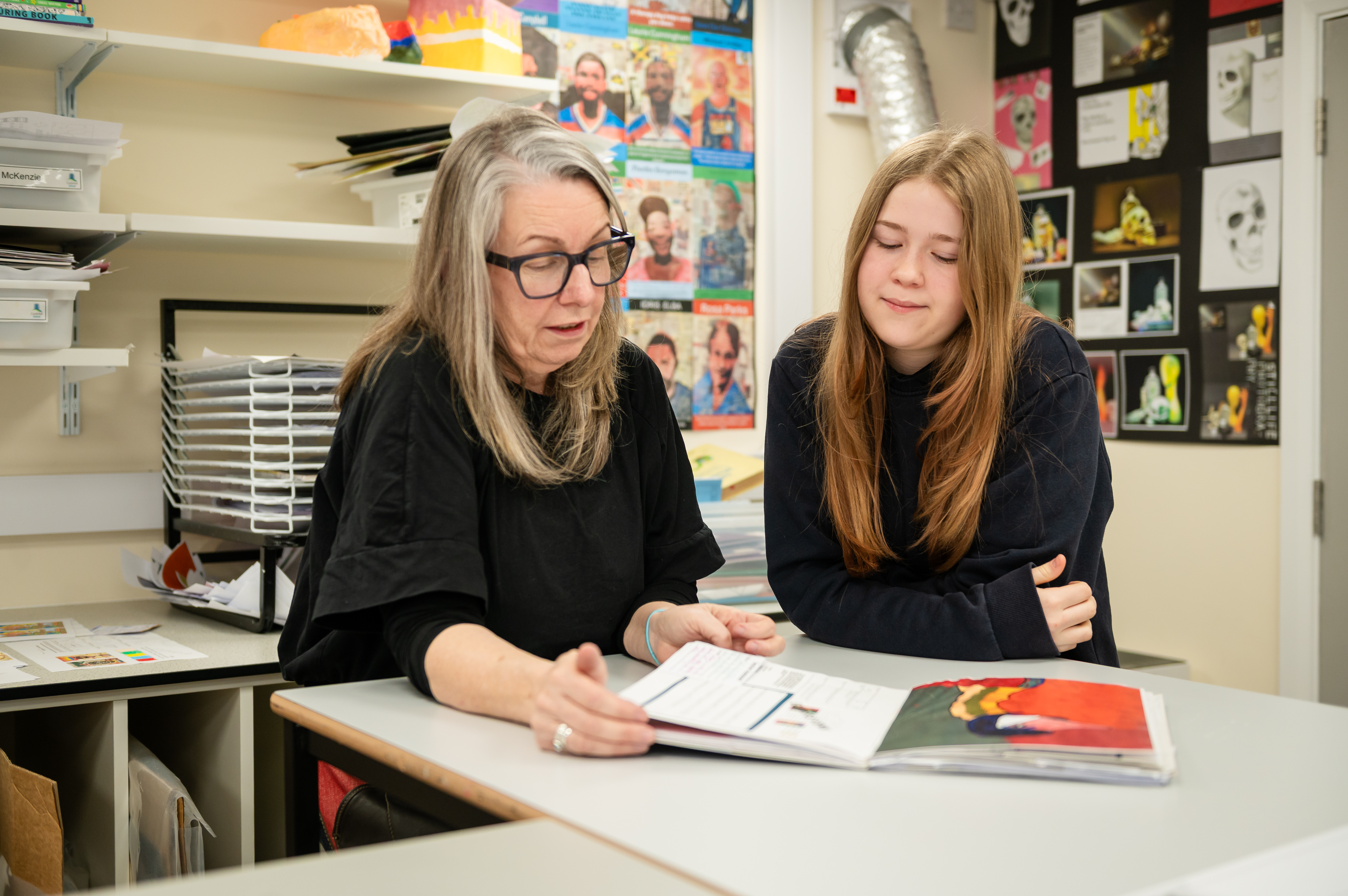 Pupil and student from Castlefell School loking at art book