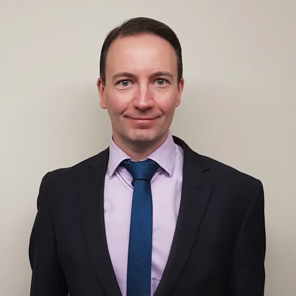 Chris Newiss, Head Teacher at Cumberland School wearing a suit