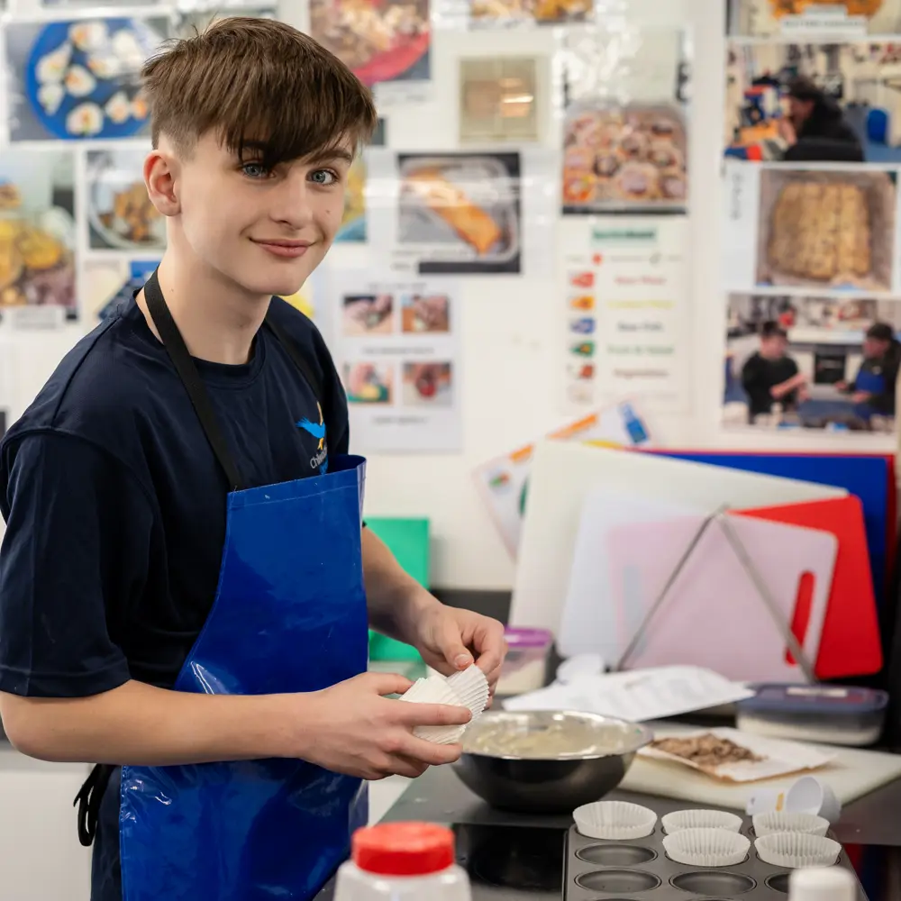 A young boy baking cakes at Chilworth House Upper School