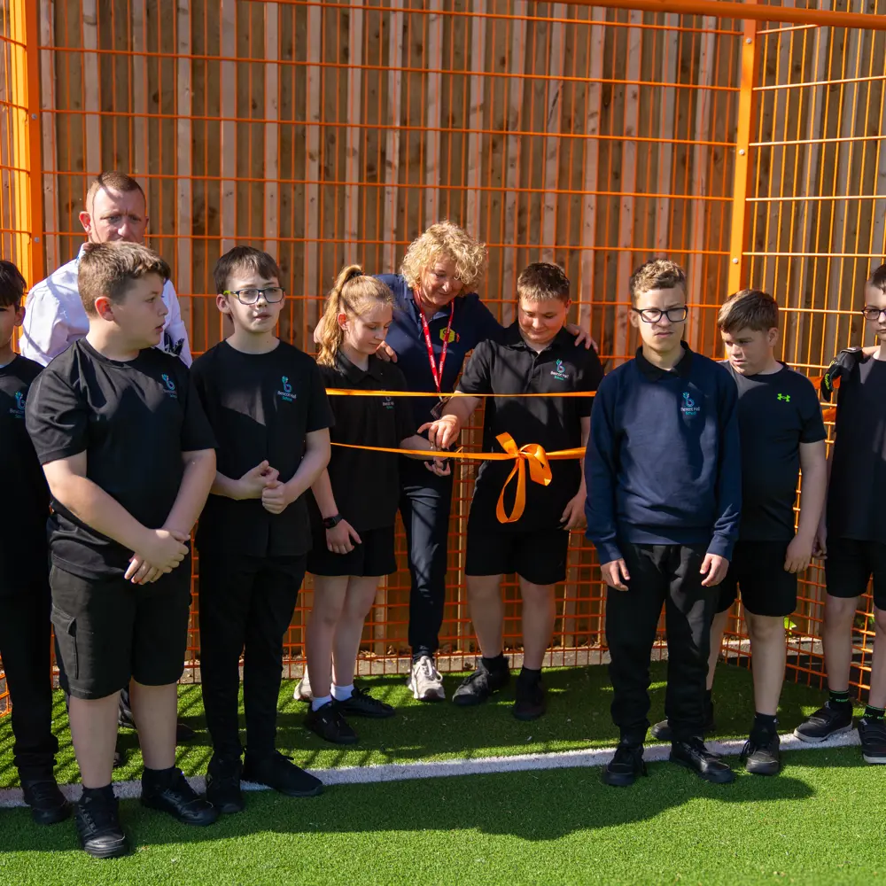 Pupils at Bescot Hall School cutting an orange ribbon for the Cruyff Court Opening