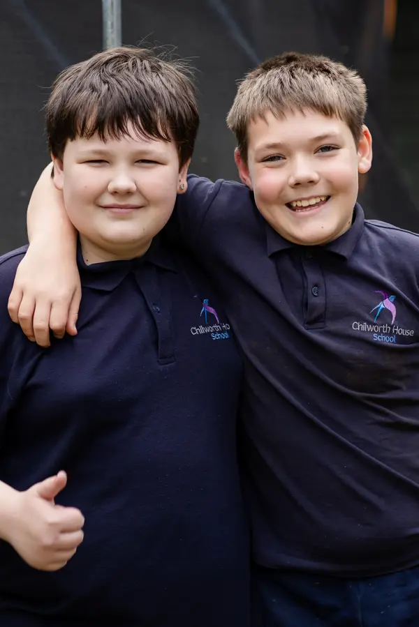 Two Young boys at Chilworth House School wearing their school uniform smiling at the camera