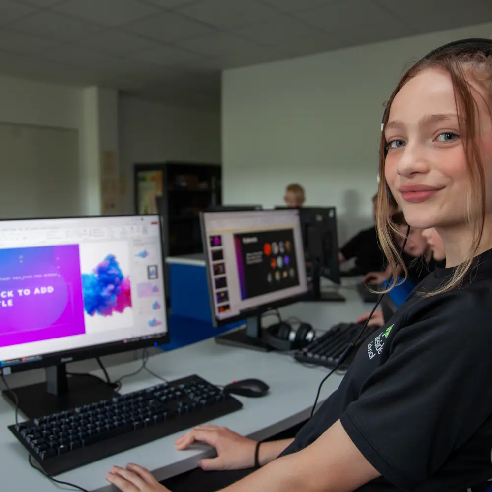 A young girl at Lakeside School using a computer and headphones