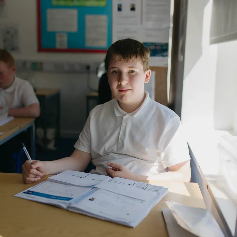 Young boy at Hartwell School sitting at a desk doing school work