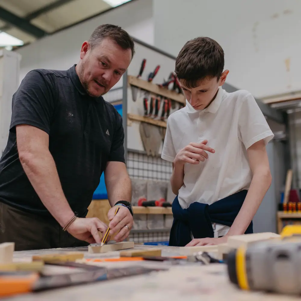 Young boy and teacher from Hall Cliffe School learning in a workshop