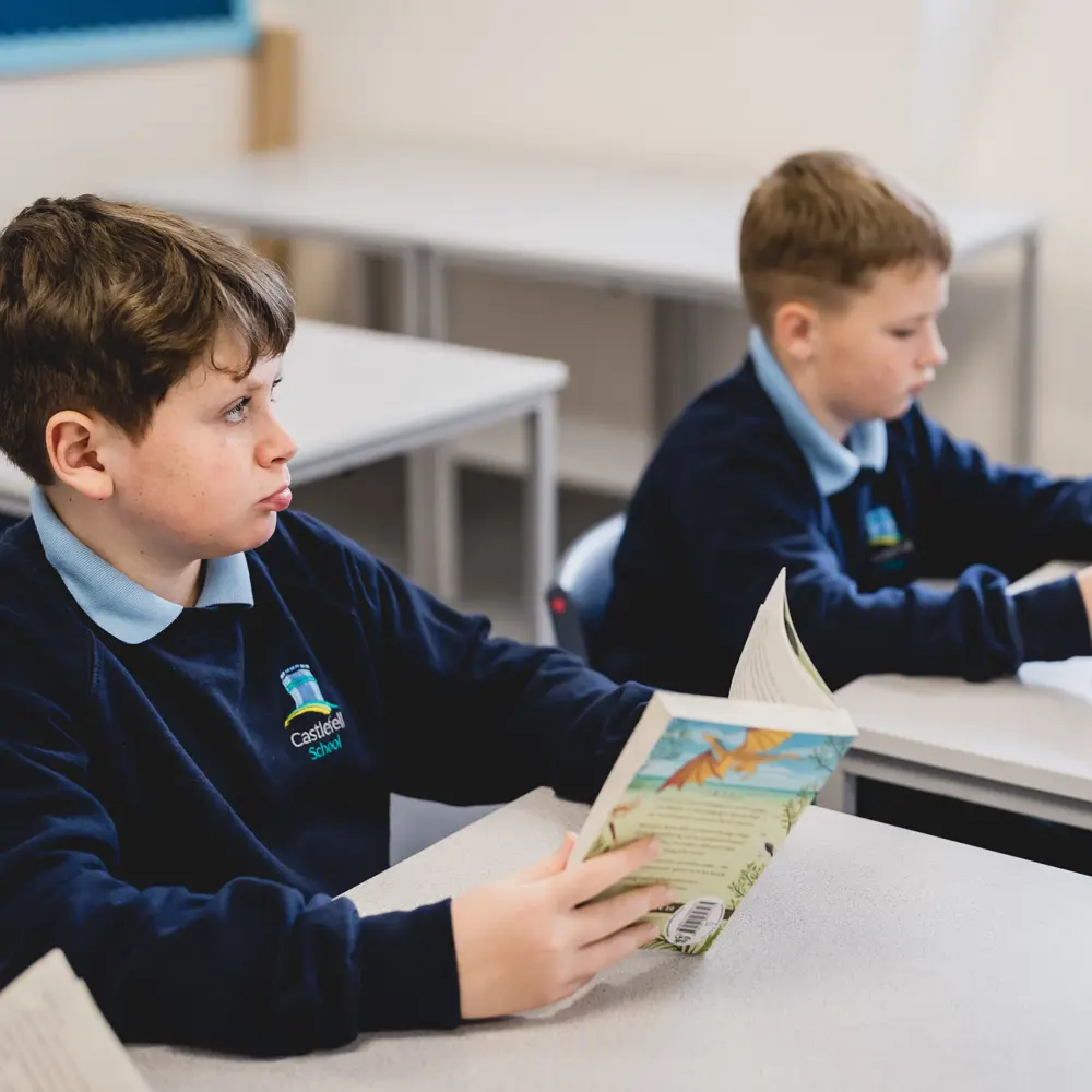 Two young boys at Castlefell School sitting at a desk reading
