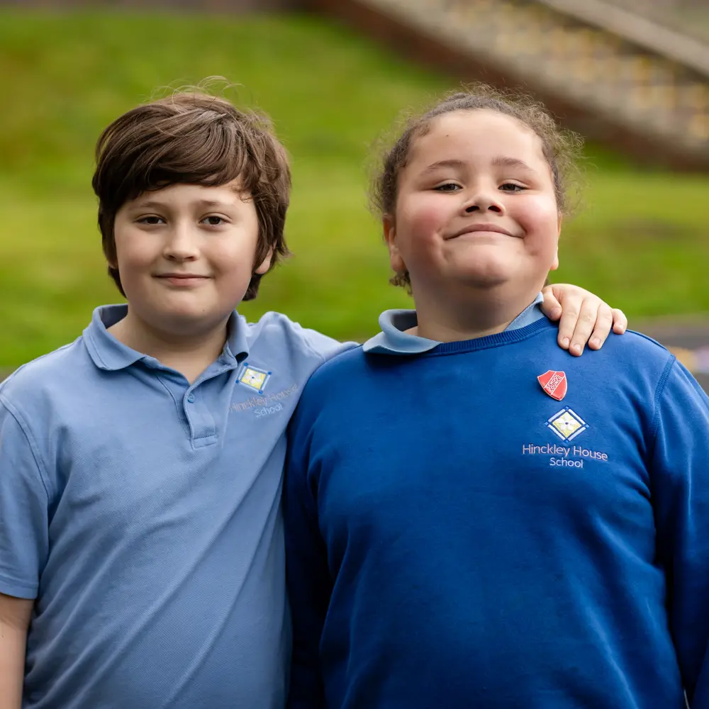 Two children from Hinckley House School standing next to each other smiling into camera