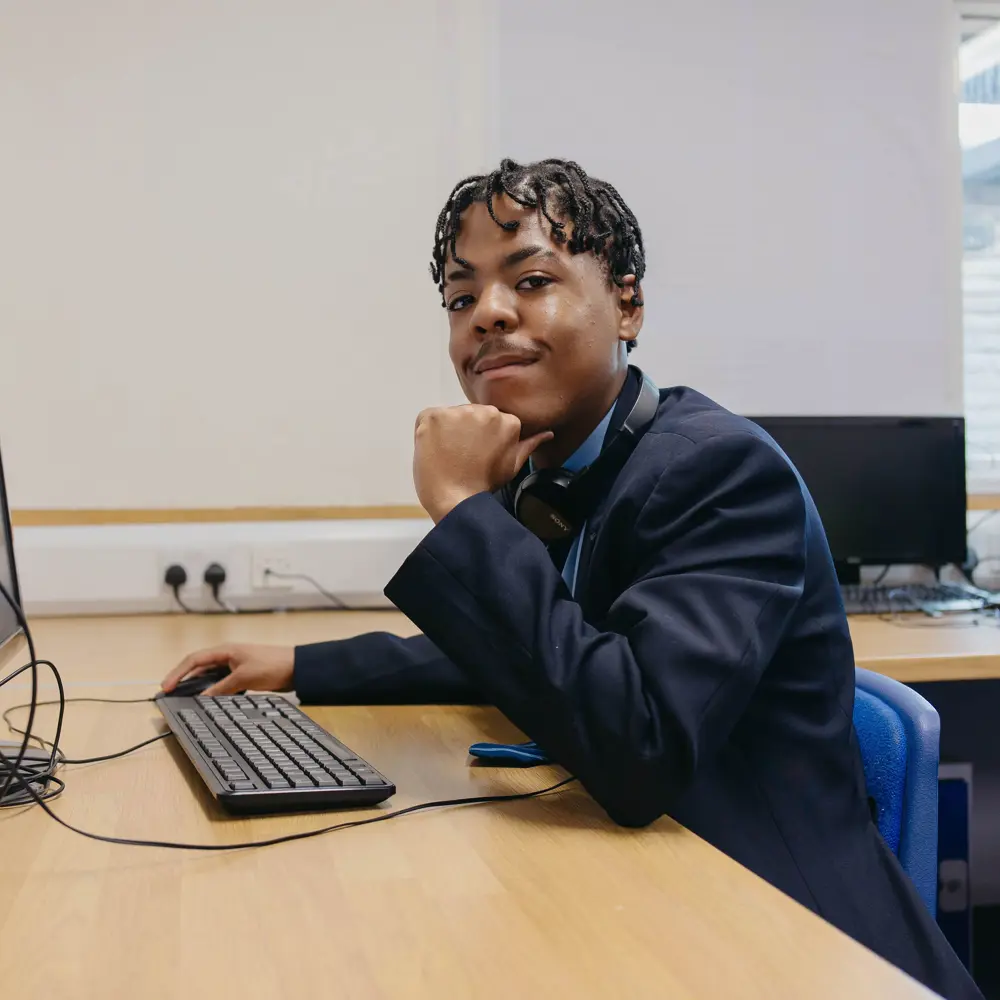 A young boy at Bridgeway School working at a computer desk