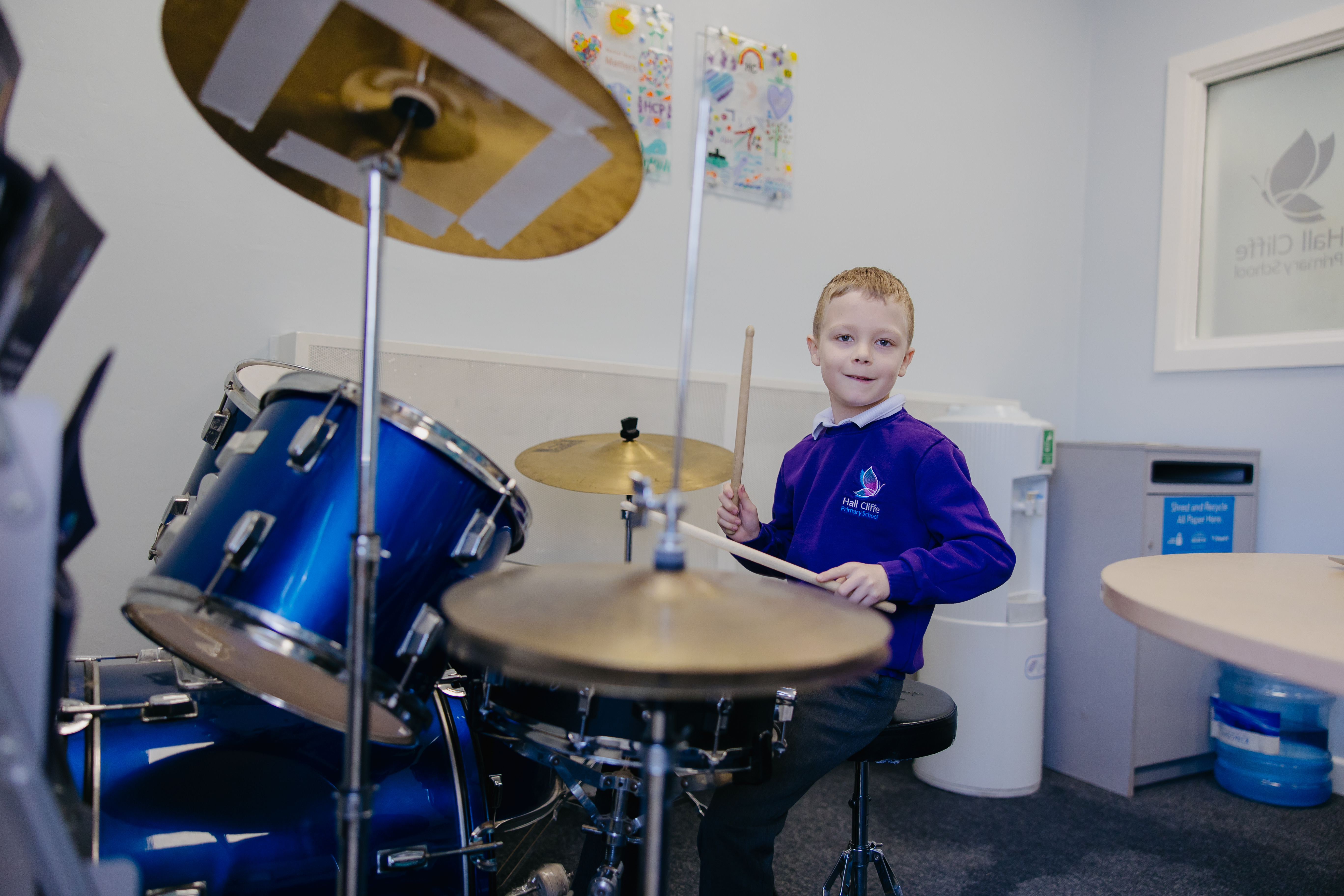 Boy playing drums while smiling