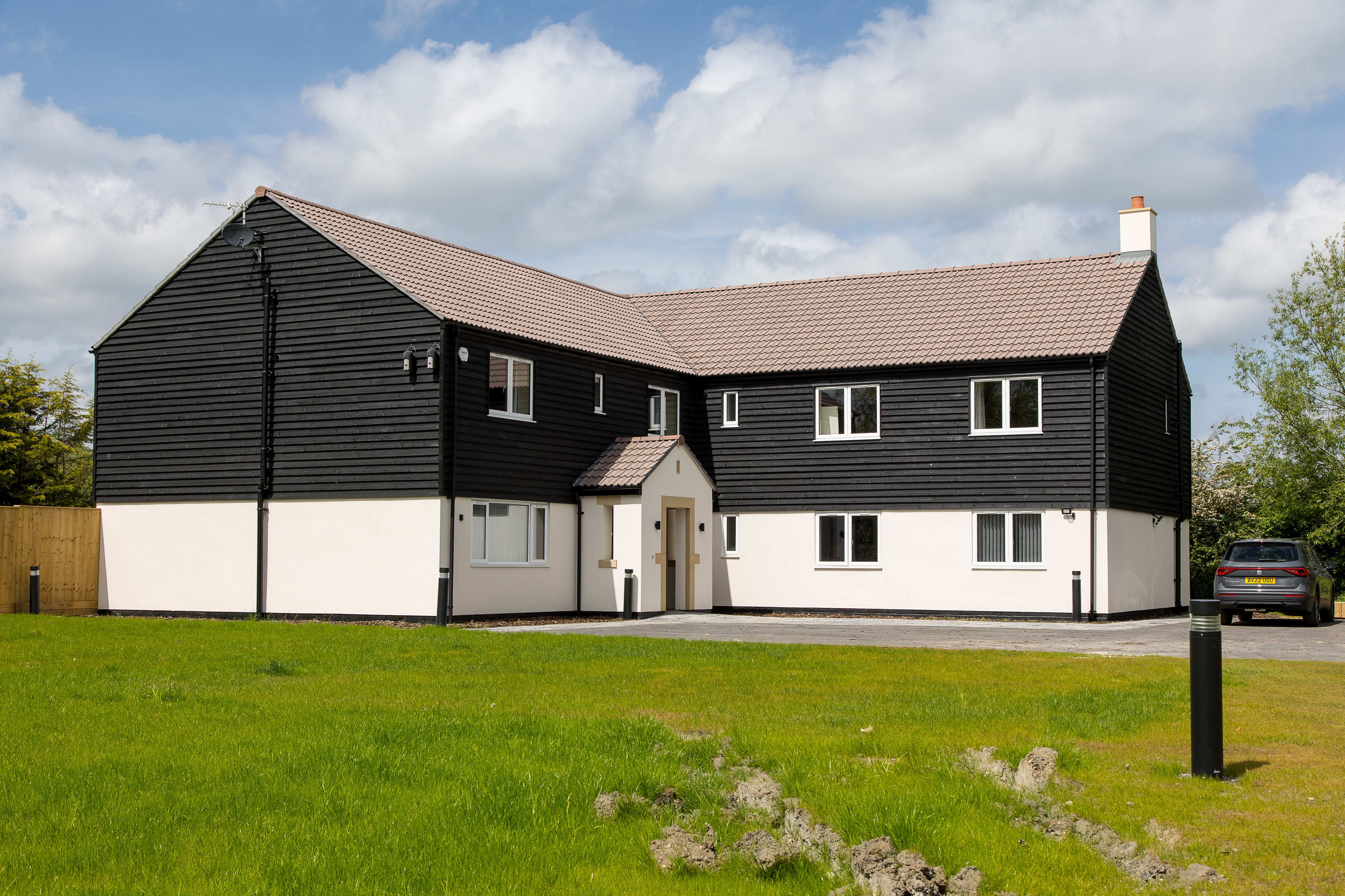 The outside of Eavesbrook Children's Home on a sunny day with freshly mowed grass