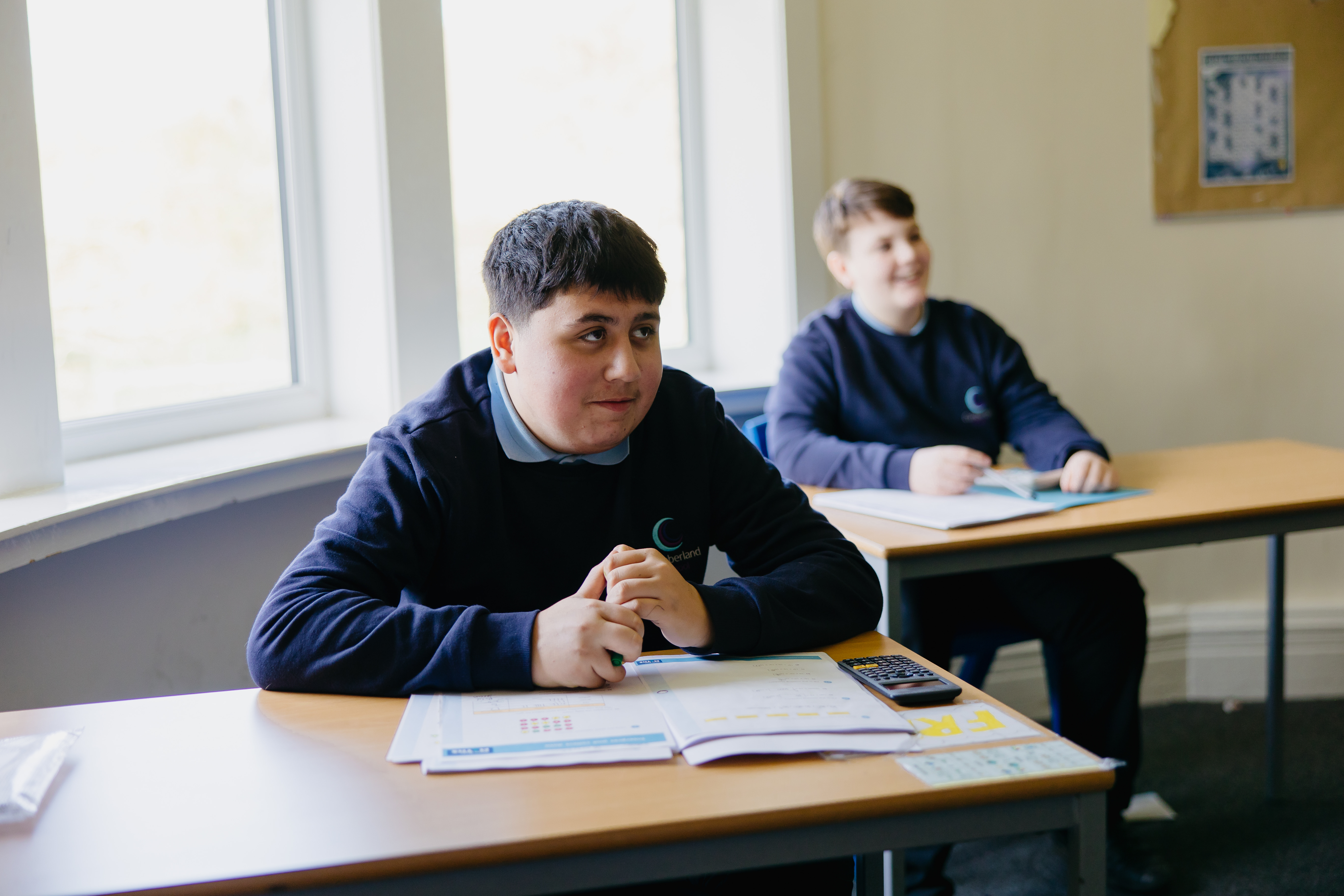 Pupil sat at desk in classroom looking at front of room