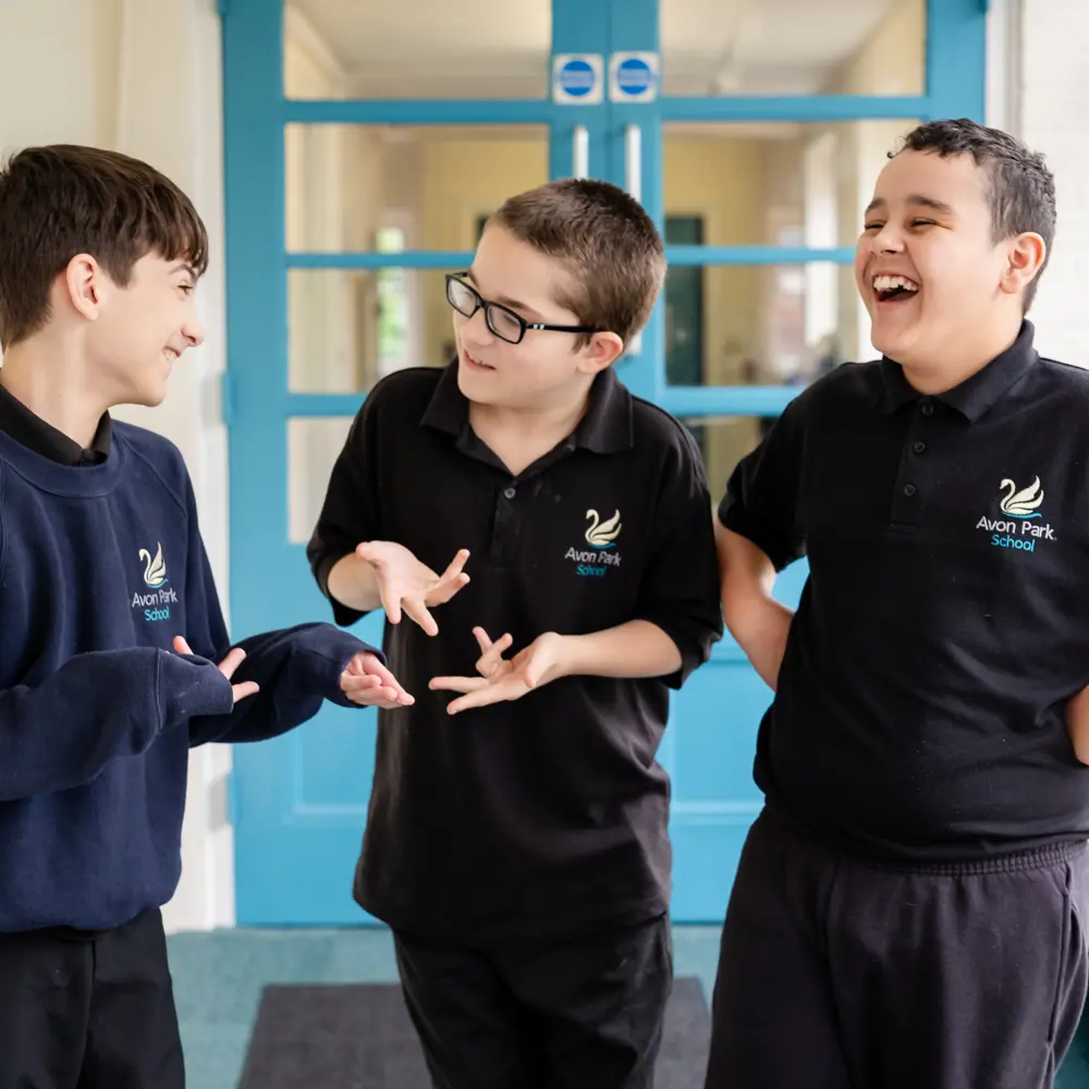 Three boys at Avon Park School laughing in the corridor