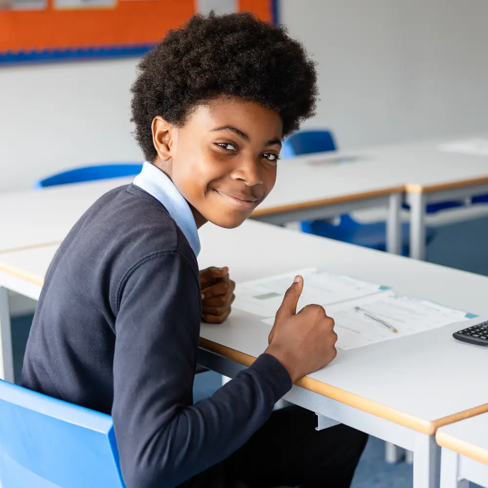 Young boy from Queensmead House School sat at a desk doing school work