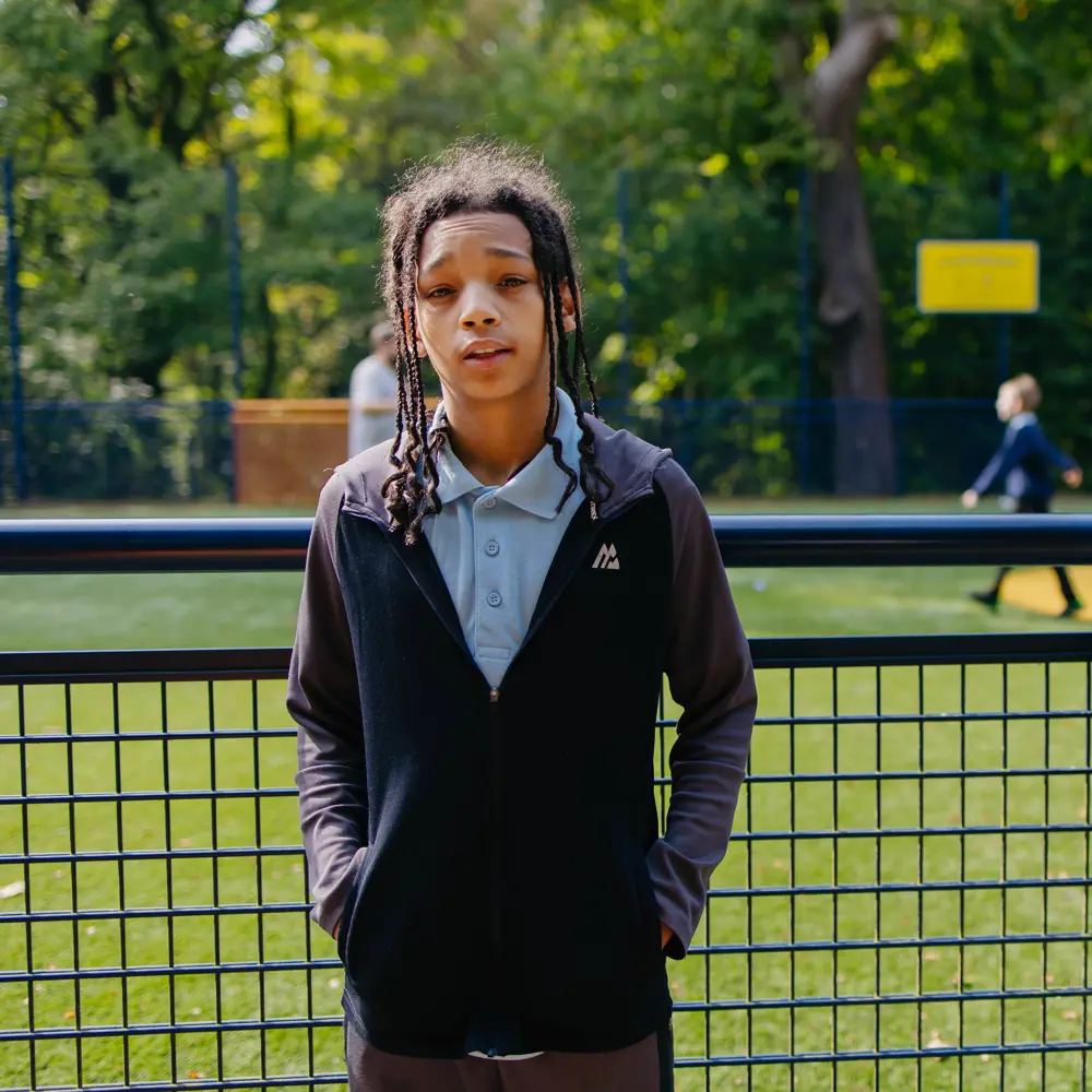 A young boy at Cumberland School outside on the court yard on a sunny day