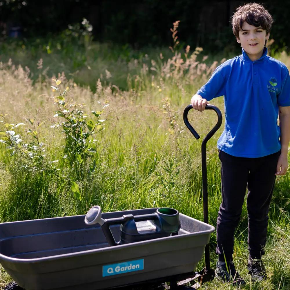 Boy from Bramley Hill School outside doing gardening