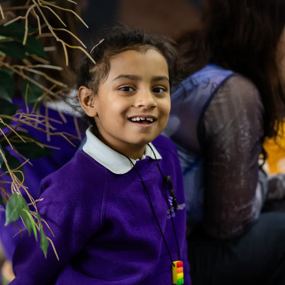 Young girl from Lavender Lodge School with dark hair and purple jumper smiling