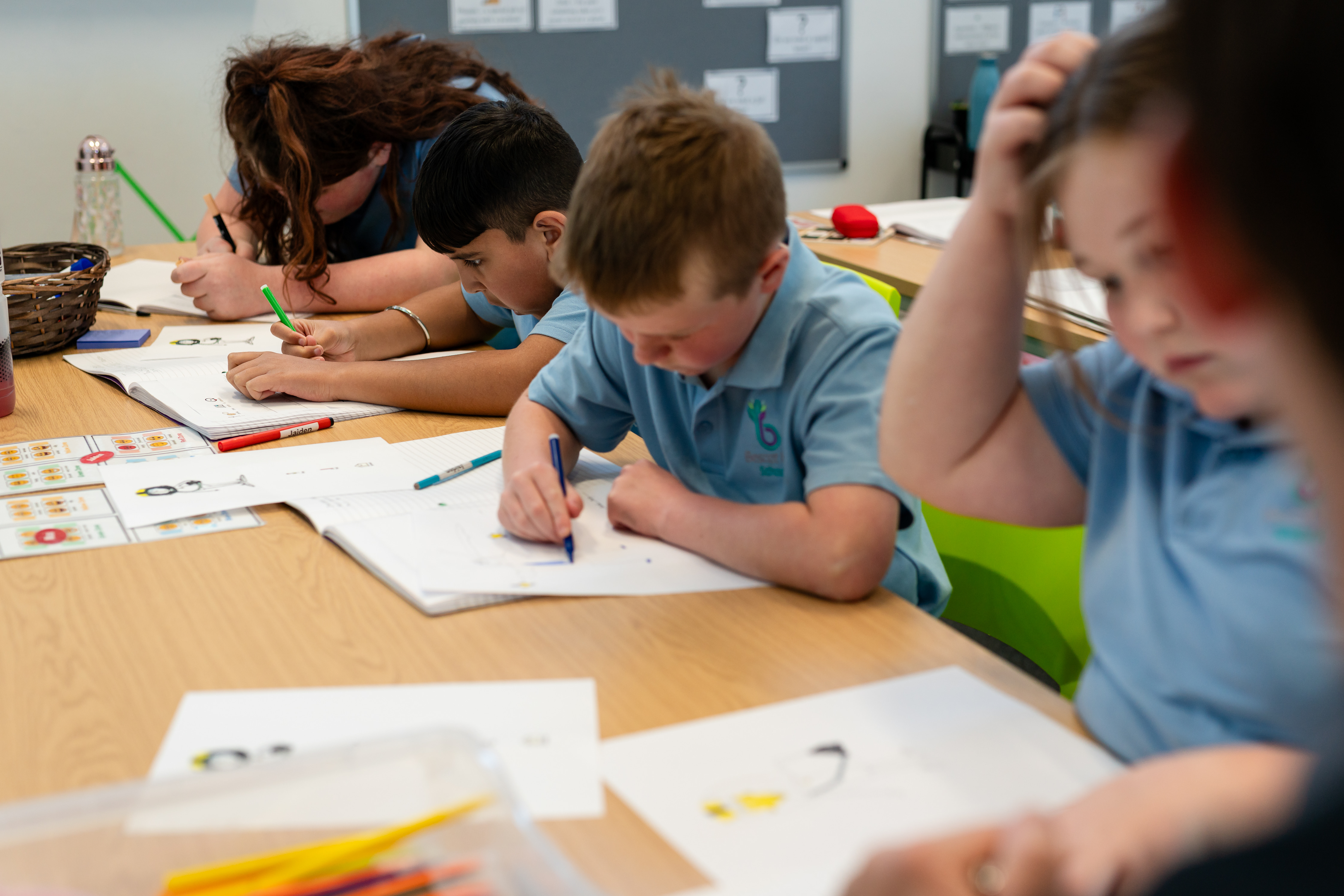 Four students sat in a row of desks focusing on school work