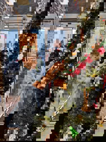 Pupil from Avon Park School hanging a decoration on a Christmas tree