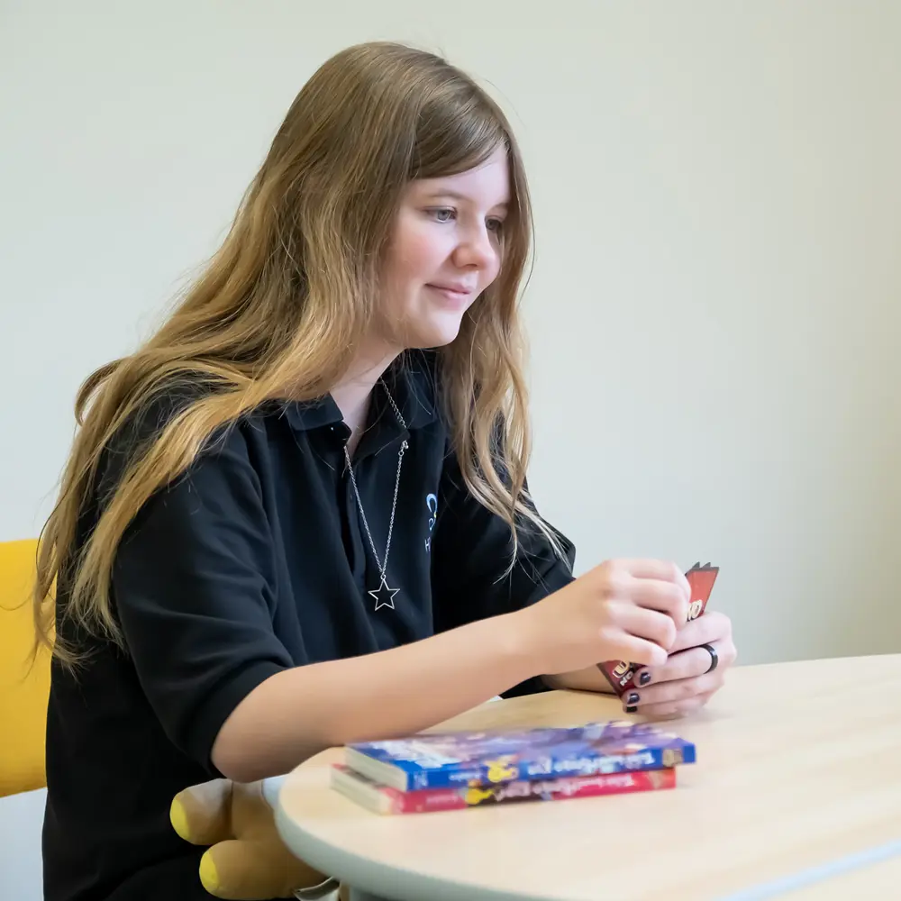 A young girl at Hilden Park School with brown hair playing uno