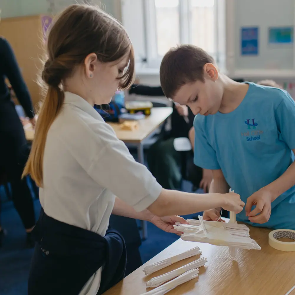 Two pupils at Hall Cliffe School working together on a project wearing their school uniform