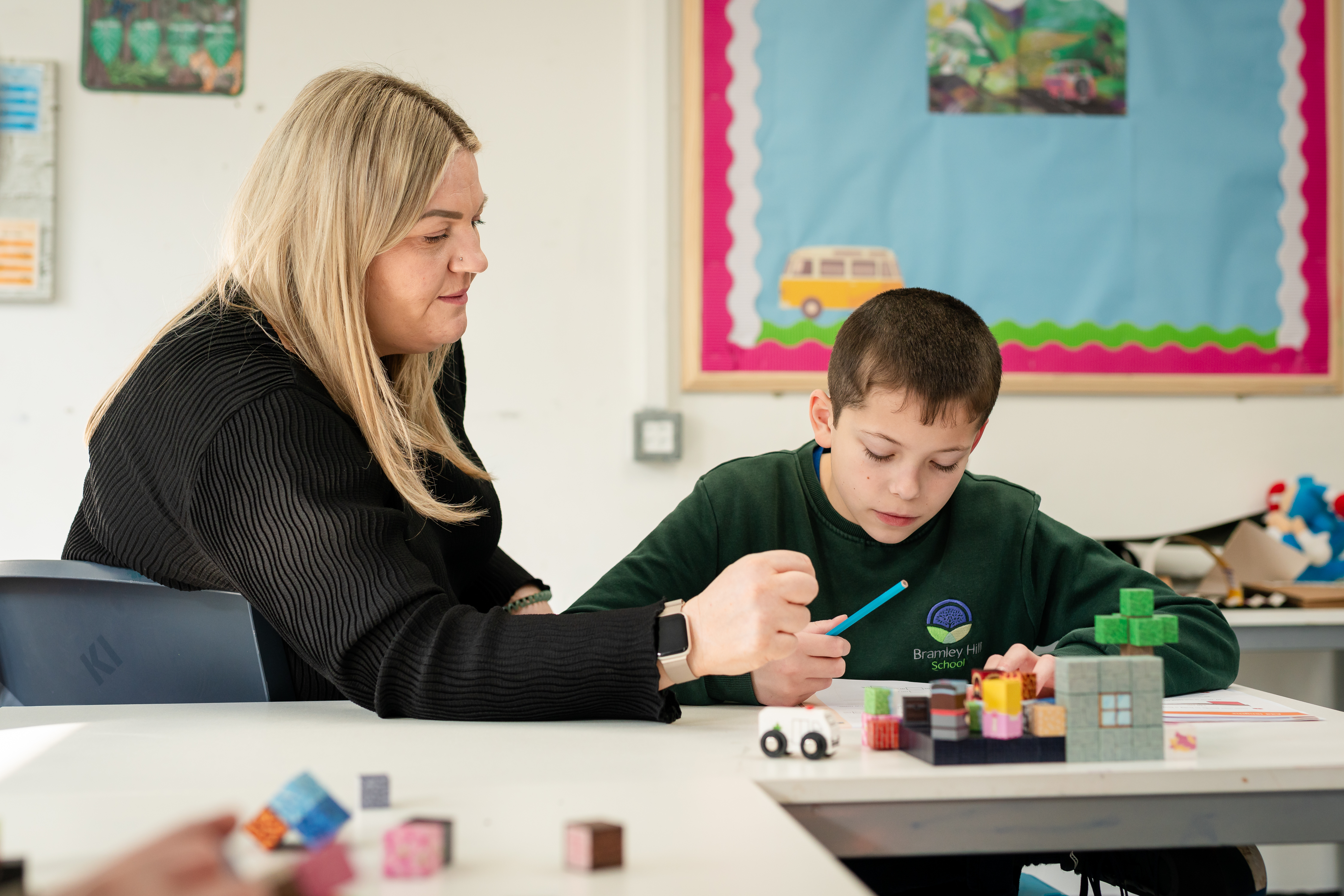 Teacher and student at desk focusing on work