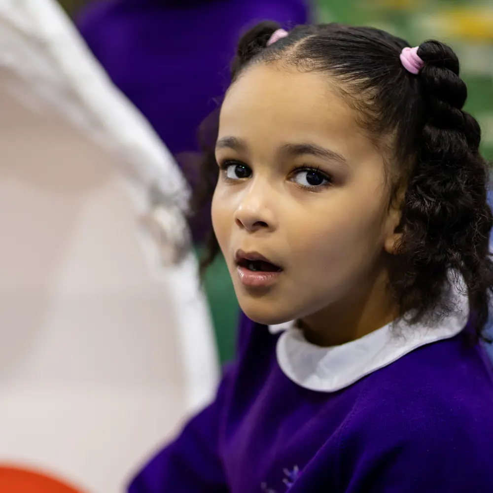 Young girl from Lavender Lodge School with dark hair and purple jumper smiling