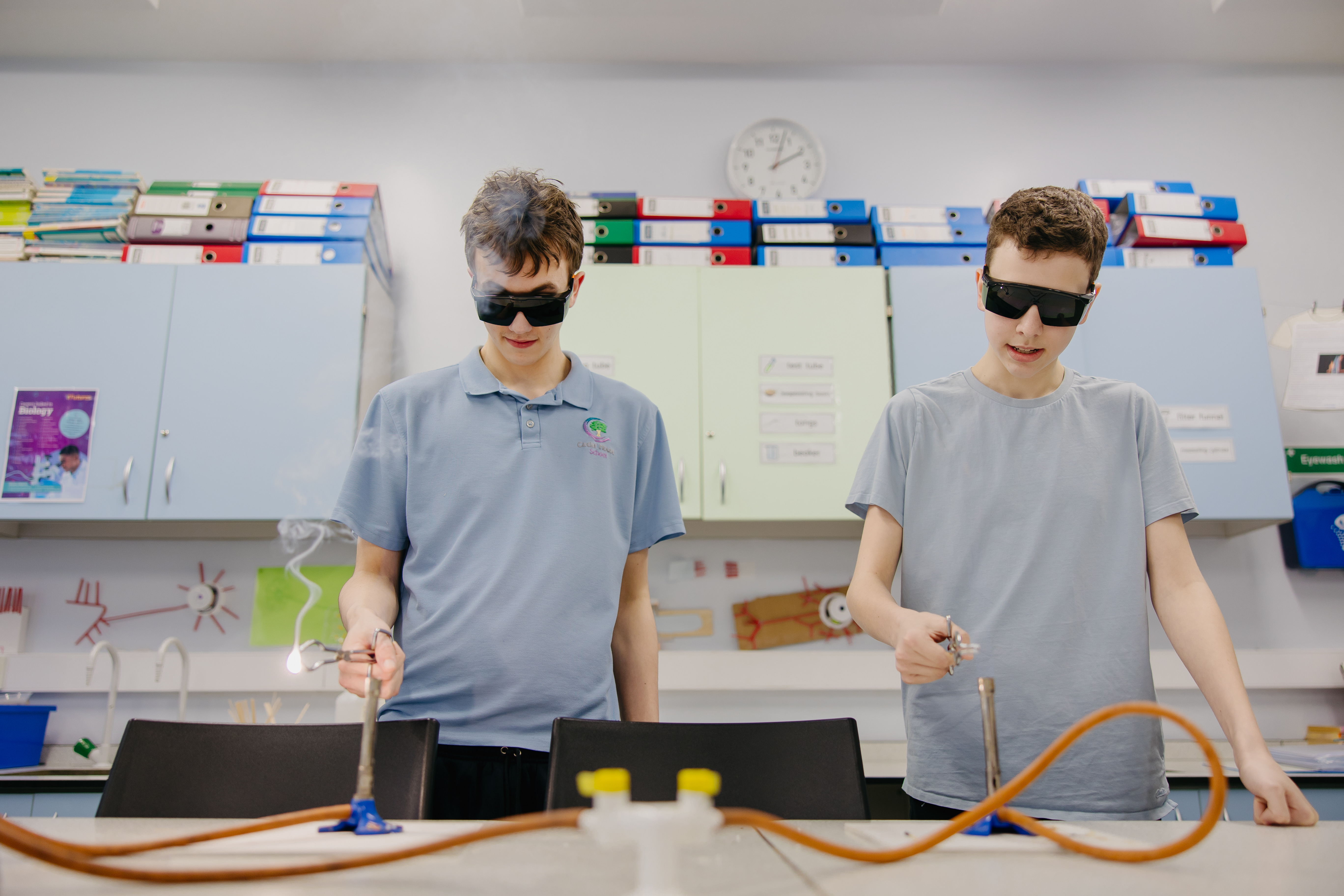 Two boys from Cedar House School using bunsen burners in classroom