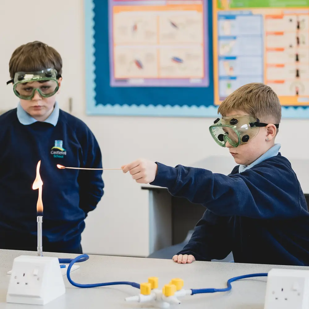 Two boys from Castlefell School using a Bunsen burner in a science lesson