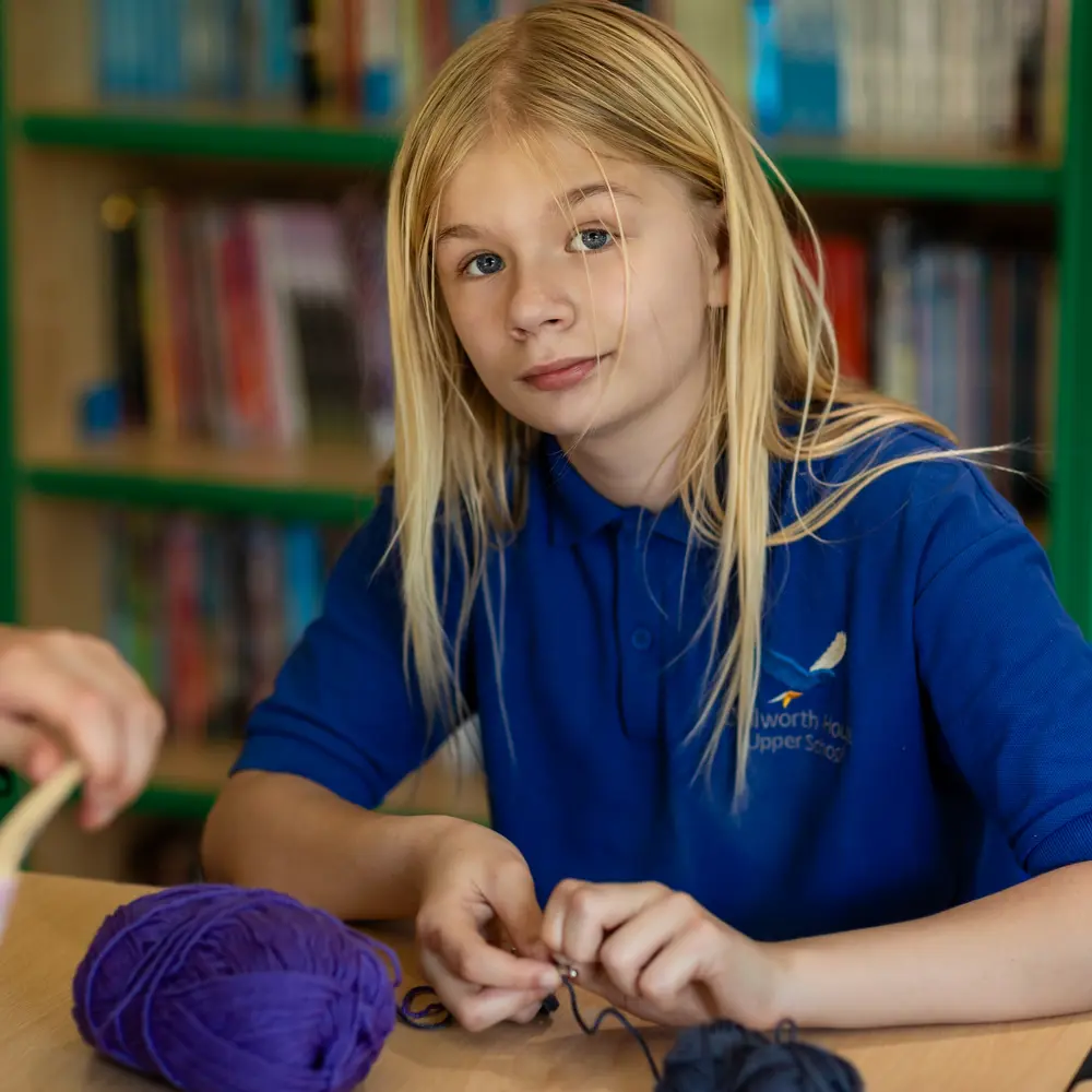 A young girl at Chilworth House upper knitting in a classroom