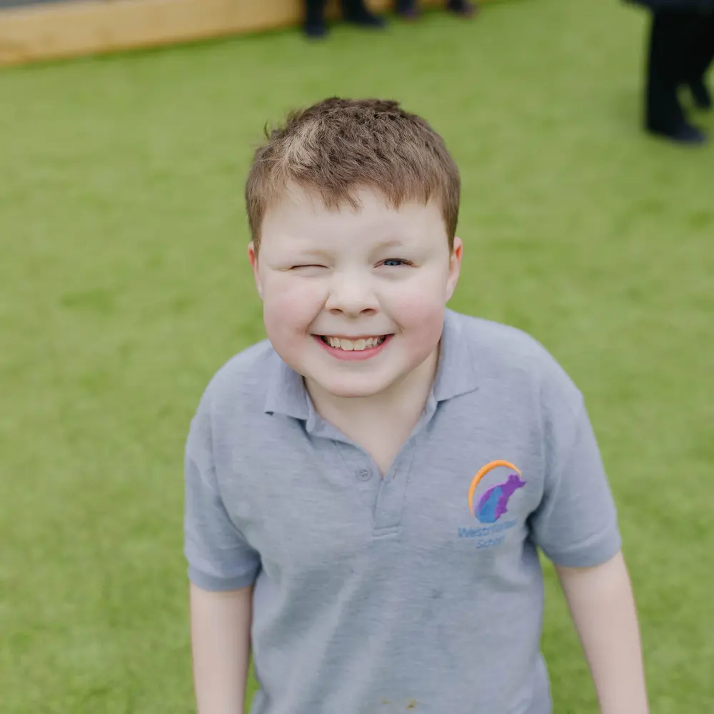 A young boy at Westmorland School smiling at the camera