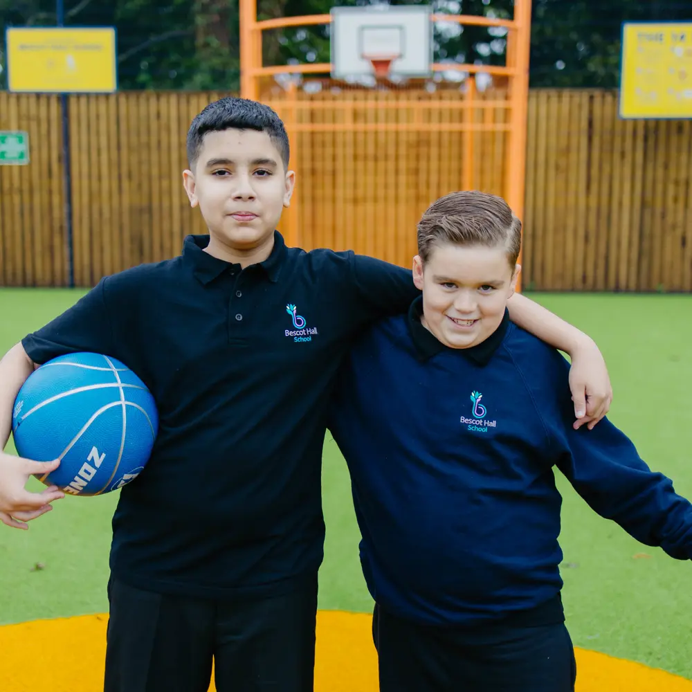 Two boys from Bescot Hall School on the sports court linking arms with each other