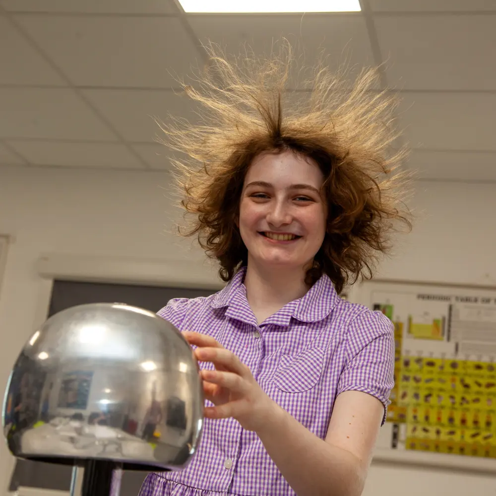 A young girl from Lakeside School in the science lesson smiling at the camera